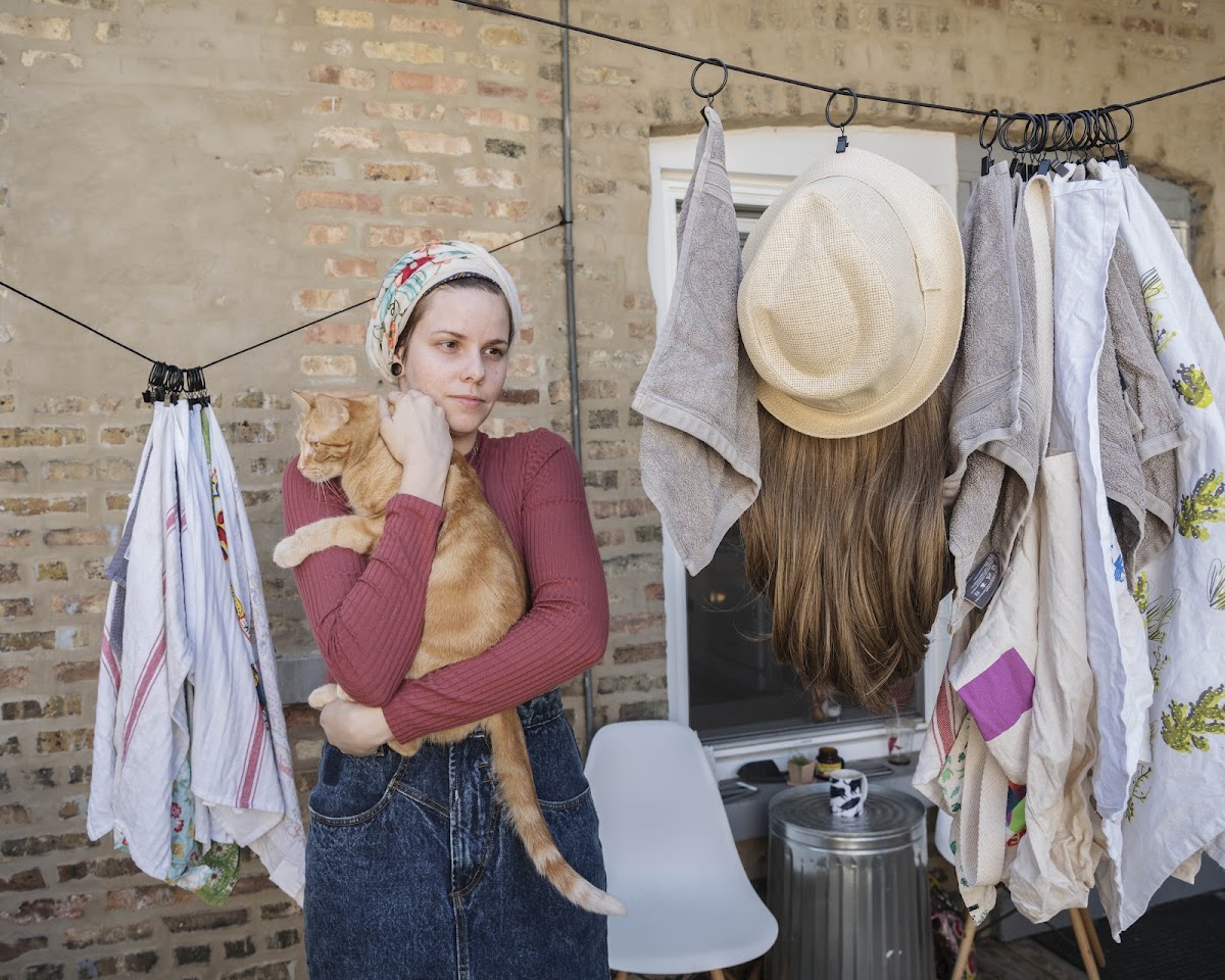 Orthodox woman doing laundry and holding a cat