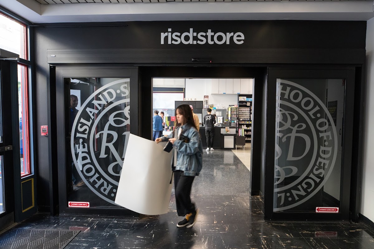 Student exiting the RISD Store holding art supples