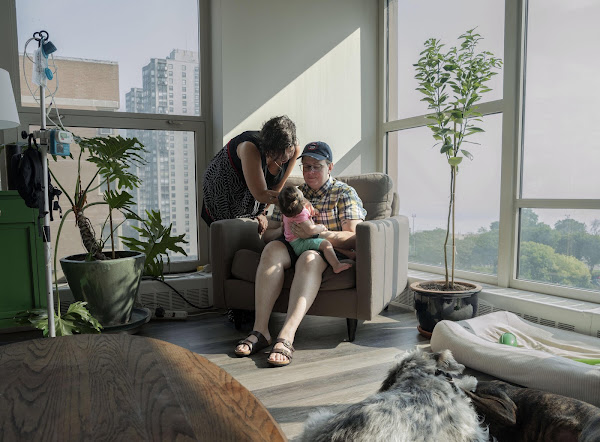 Two people sitting in a home with a baby