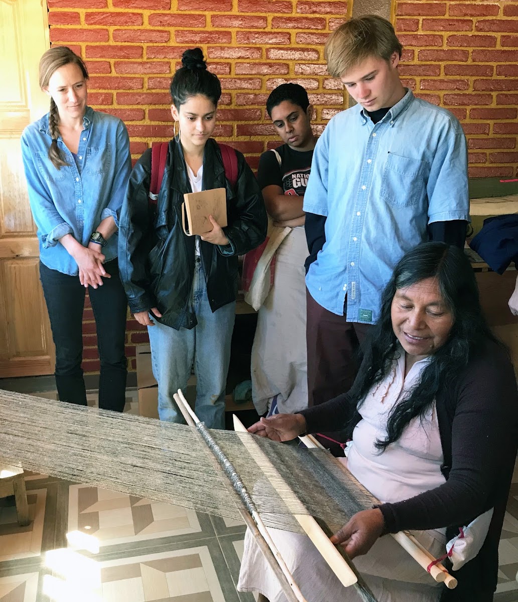 Students watching as woman weaves