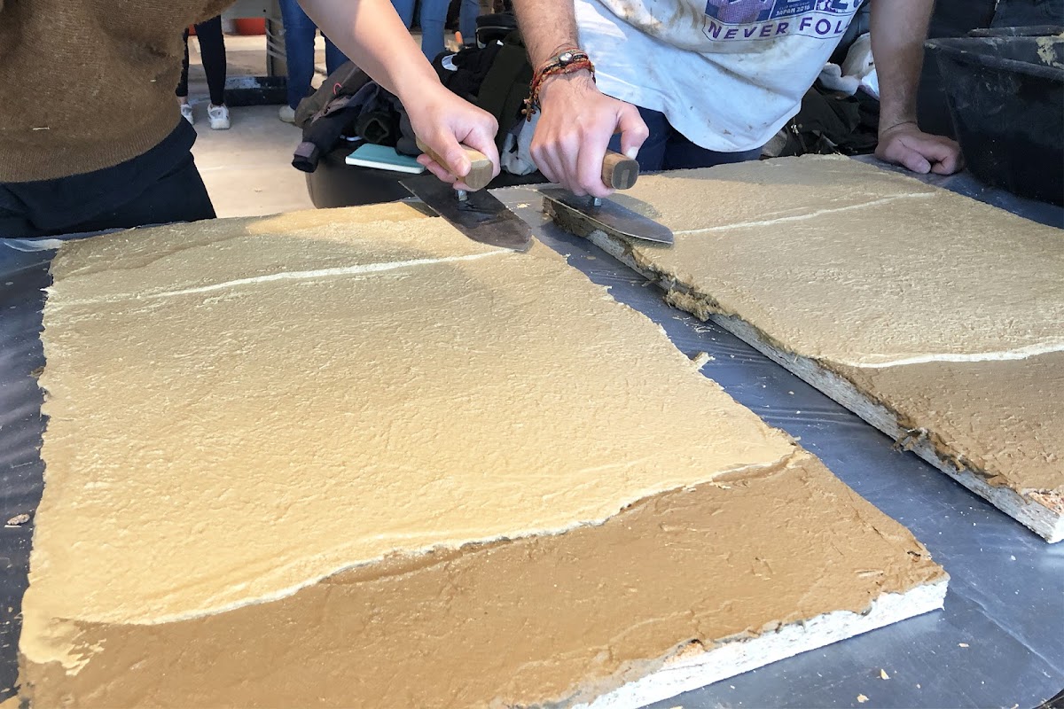 Students working with traditional Japanese plaster