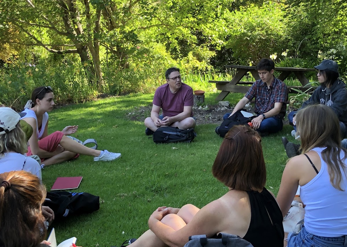 Vice Provost Dan Cavicchi sitting in a circle outside with students