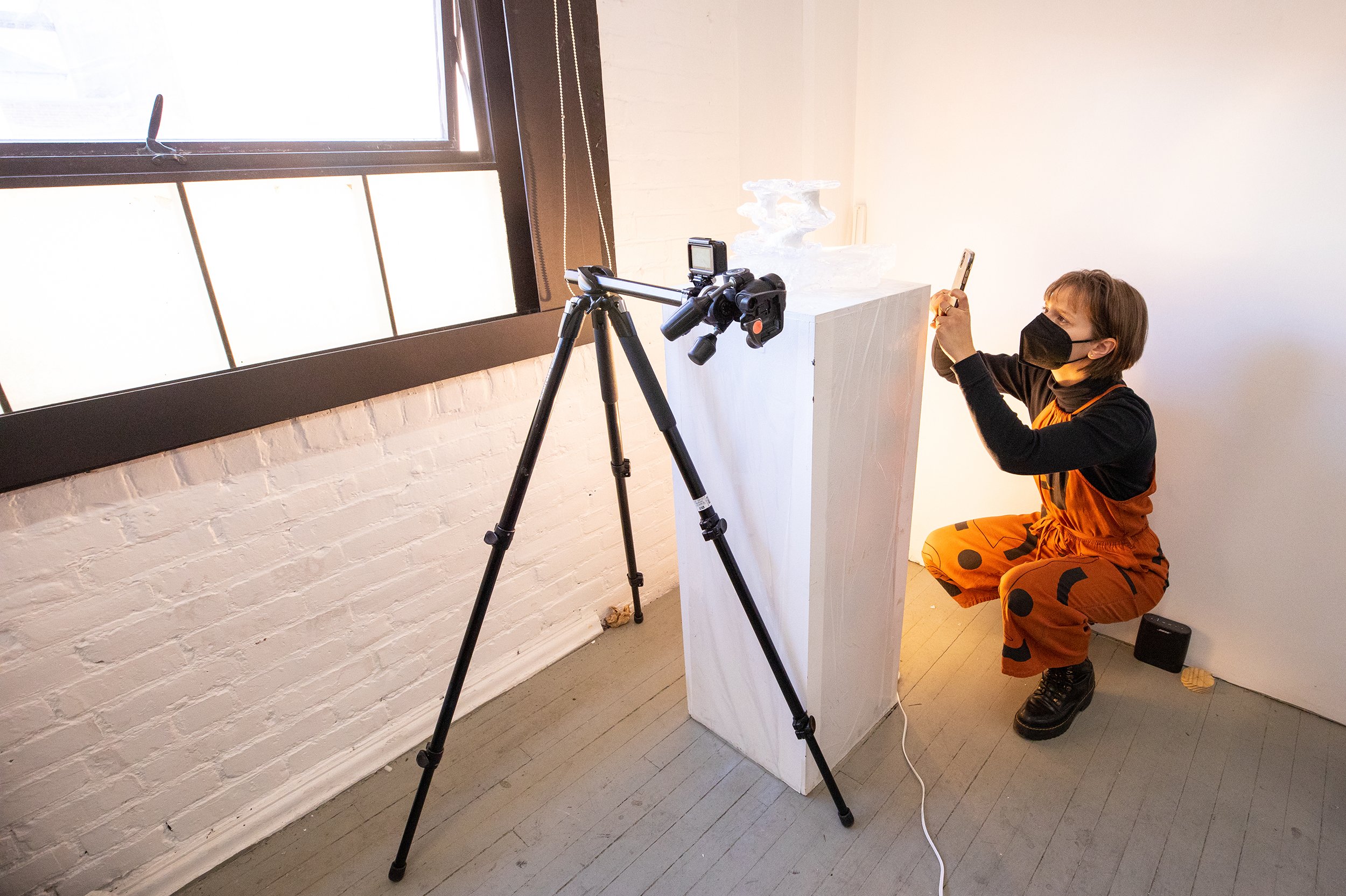 a faculty member photographs a student-made object