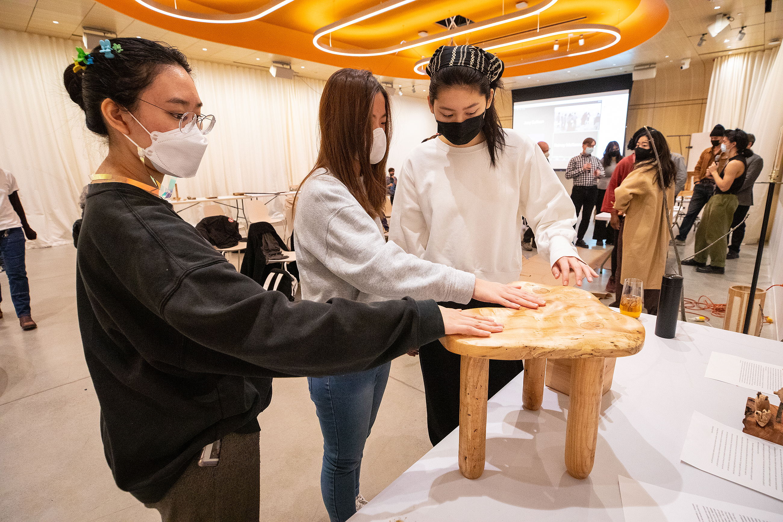 students admire a stool by Emily Lo