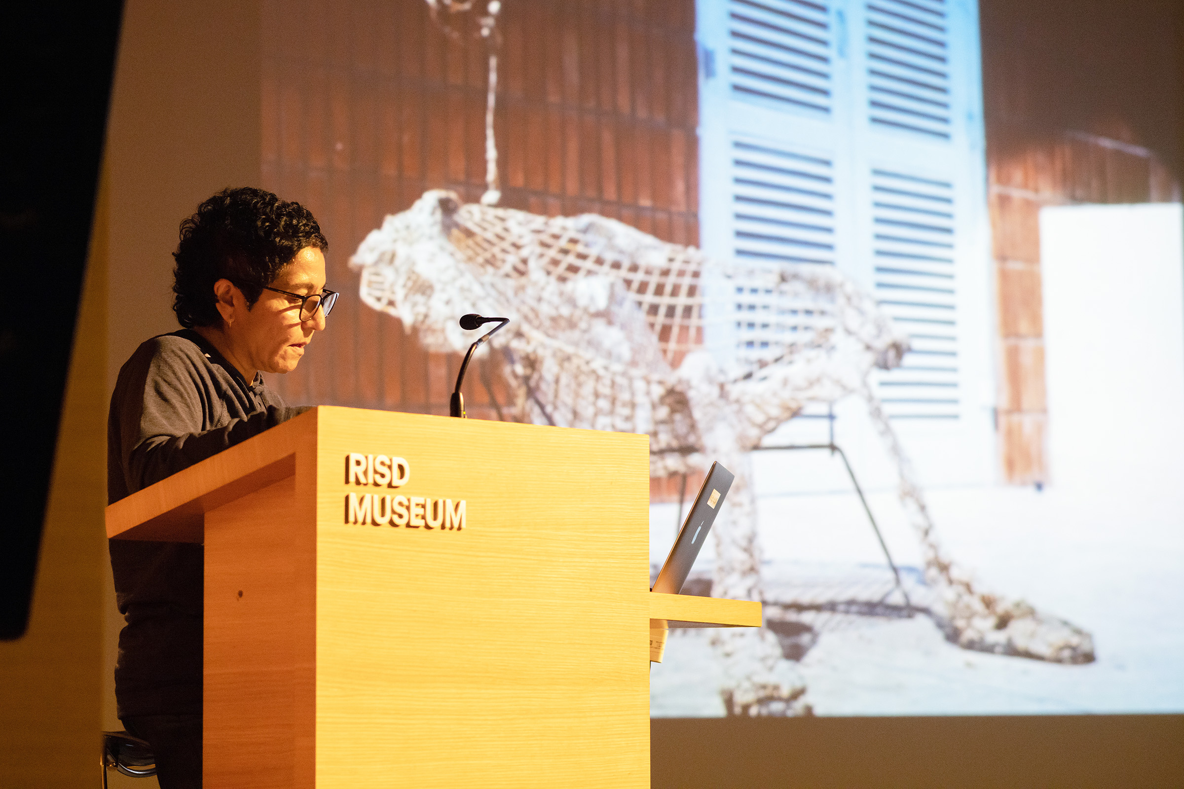 Bhabha at the podium in RISD's Metcalf Auditorium