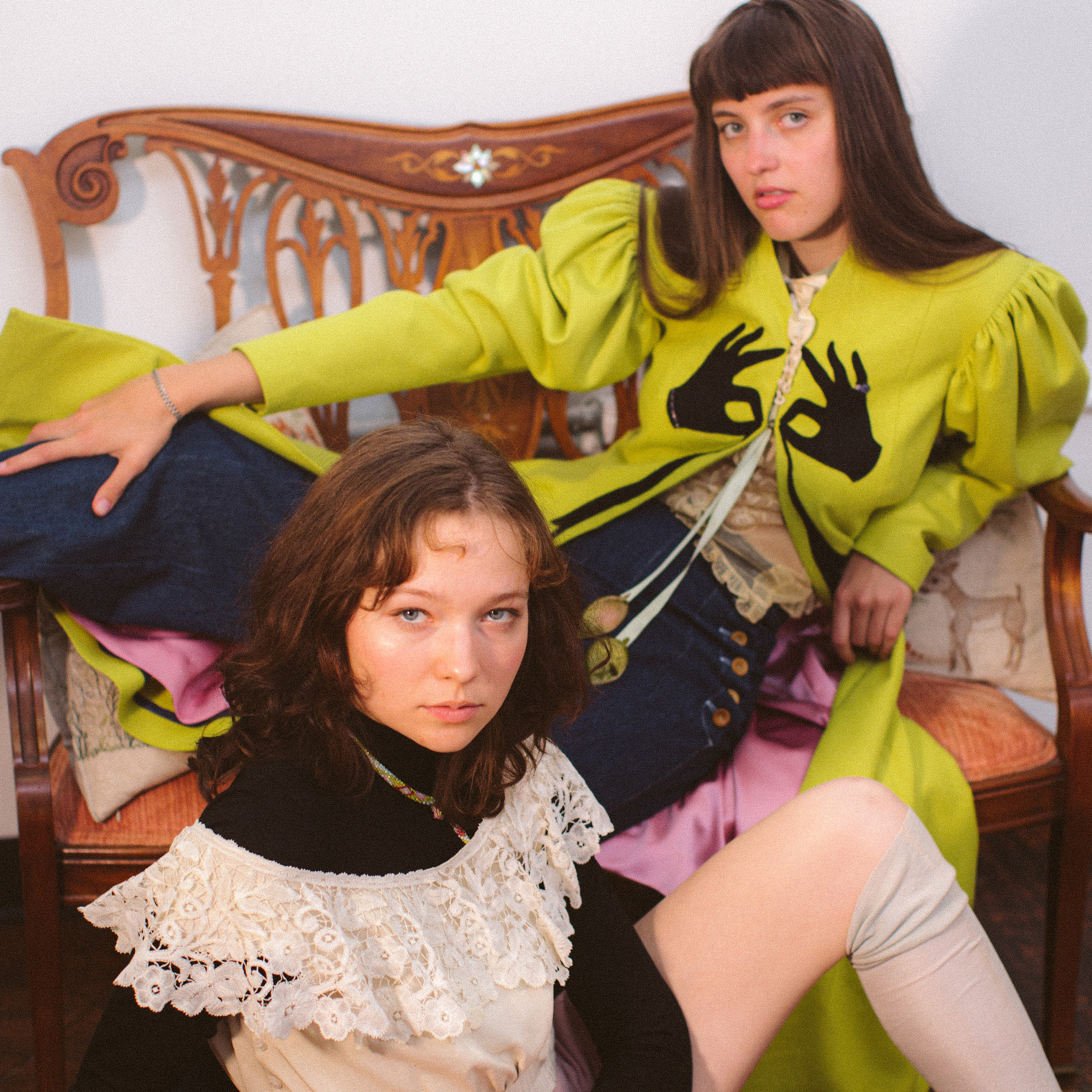 Two models pose together wearing antique clothing
