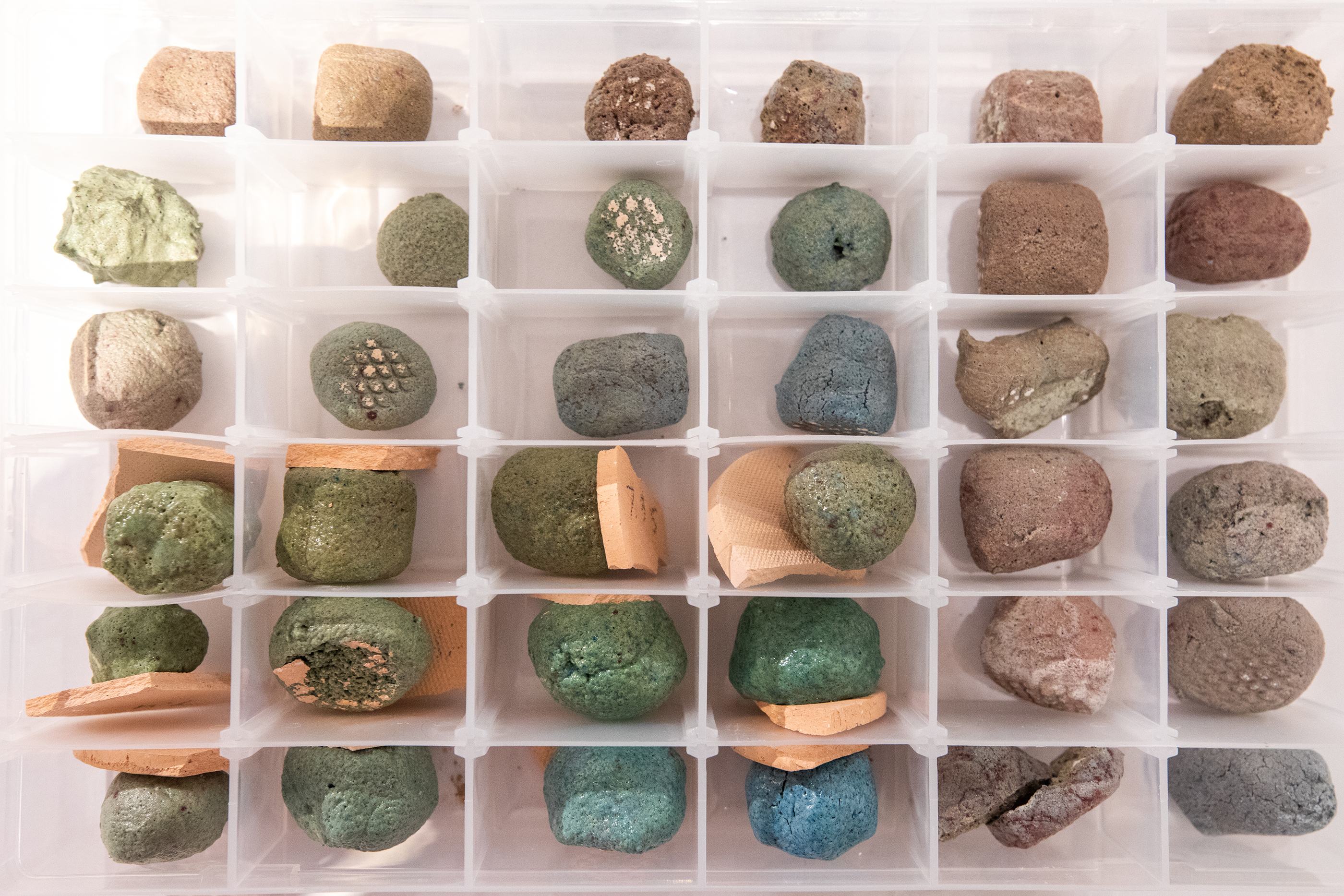 a box with many compartments containing ceramics samples