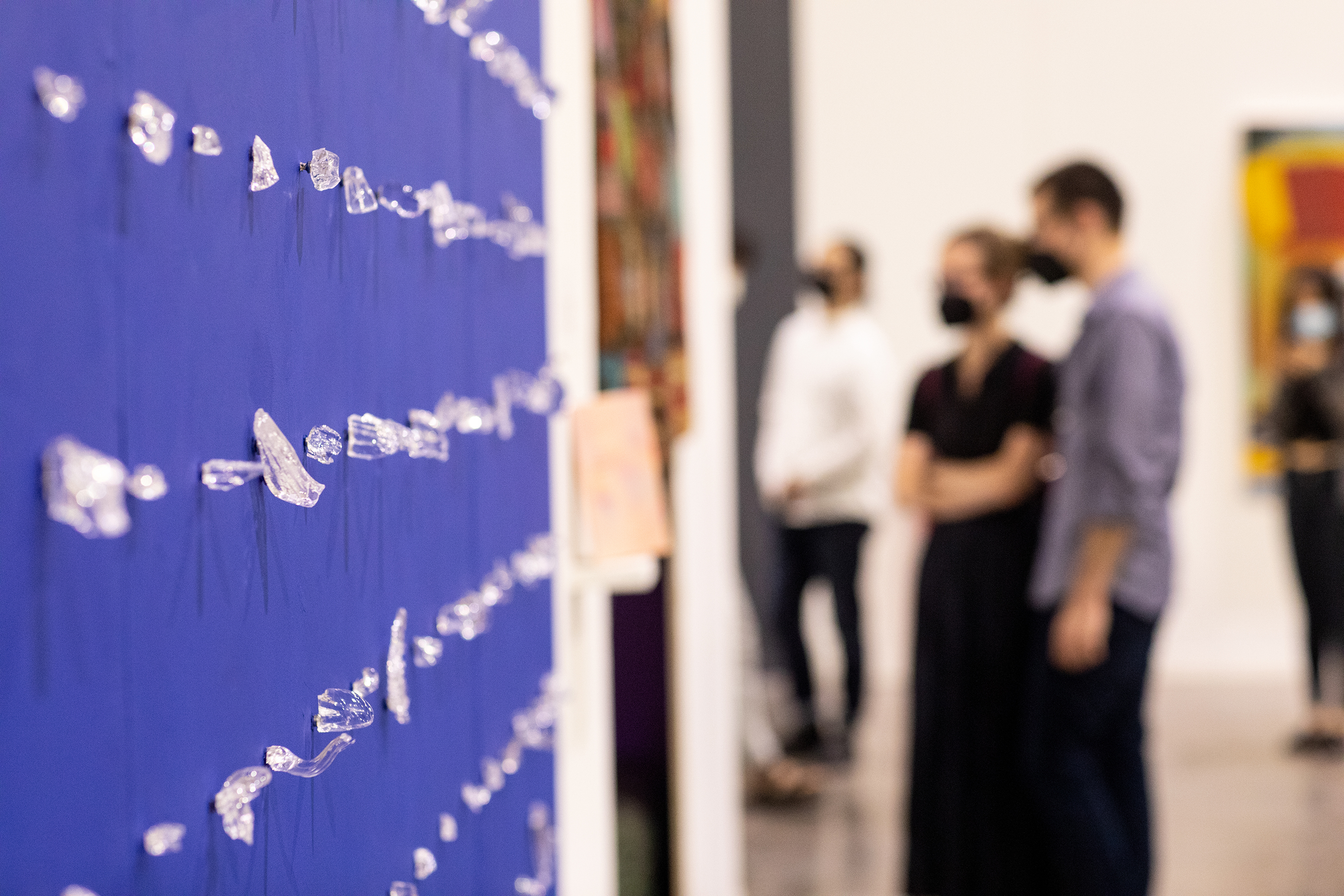 a huge selection of clear glass pieces displayed on a blue wall