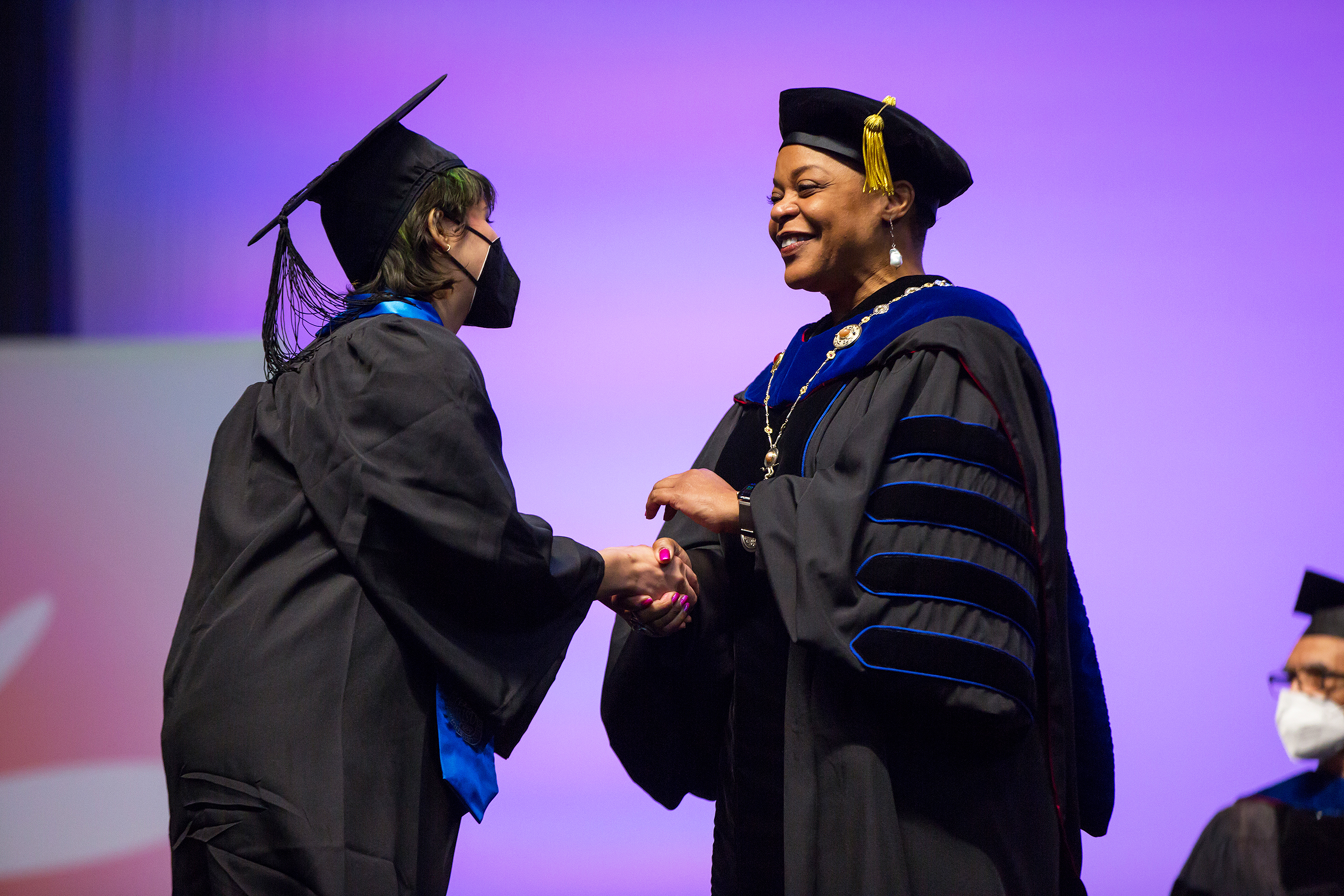 Williams shakes hands with a graduating student
