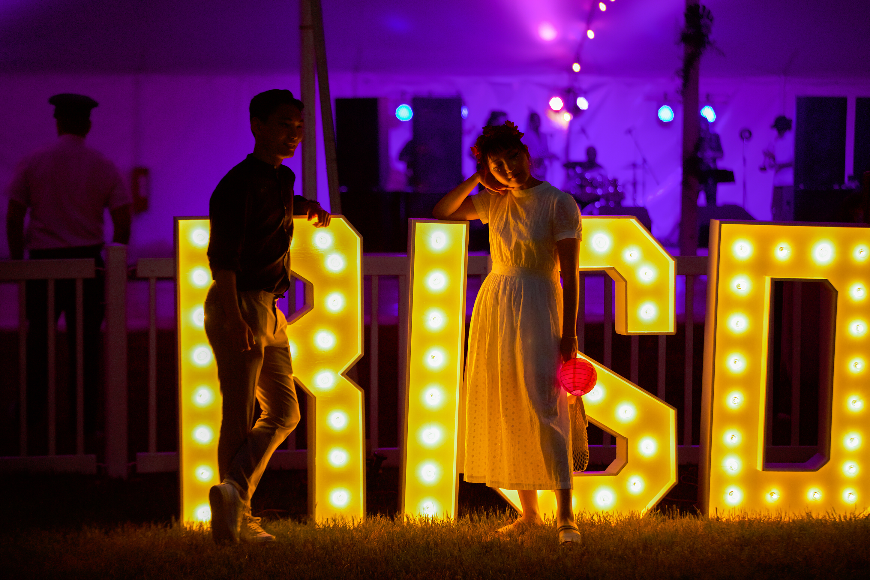 students pose in front of neon lights spelling out RISD