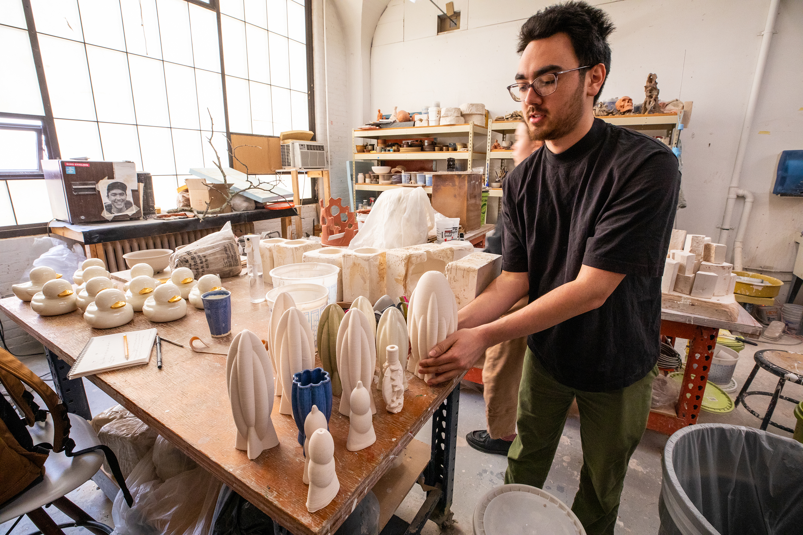a student creates ceramic vessels inspired by seed pods