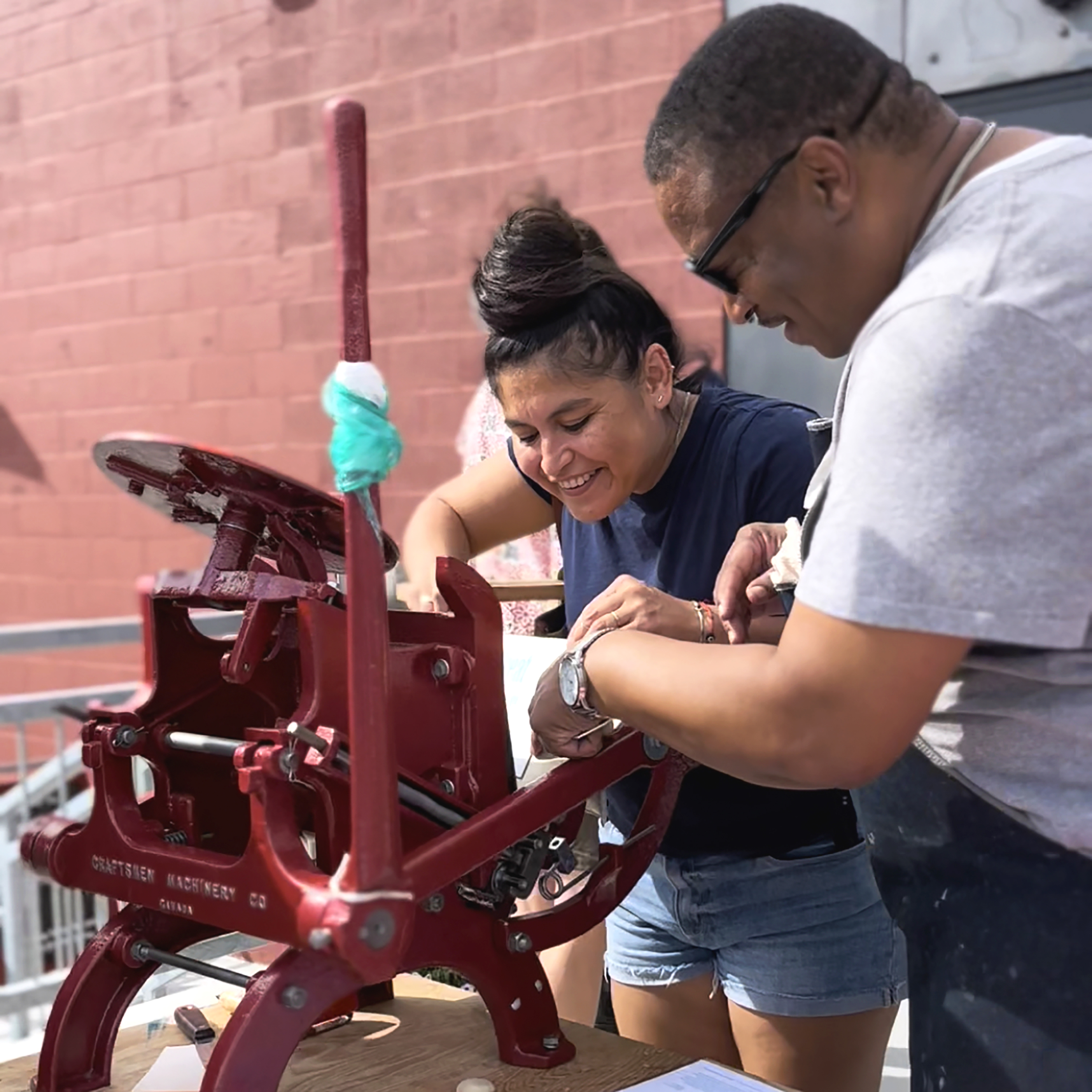 Guests using a letterpress to contribute to the making process of posters and postcards