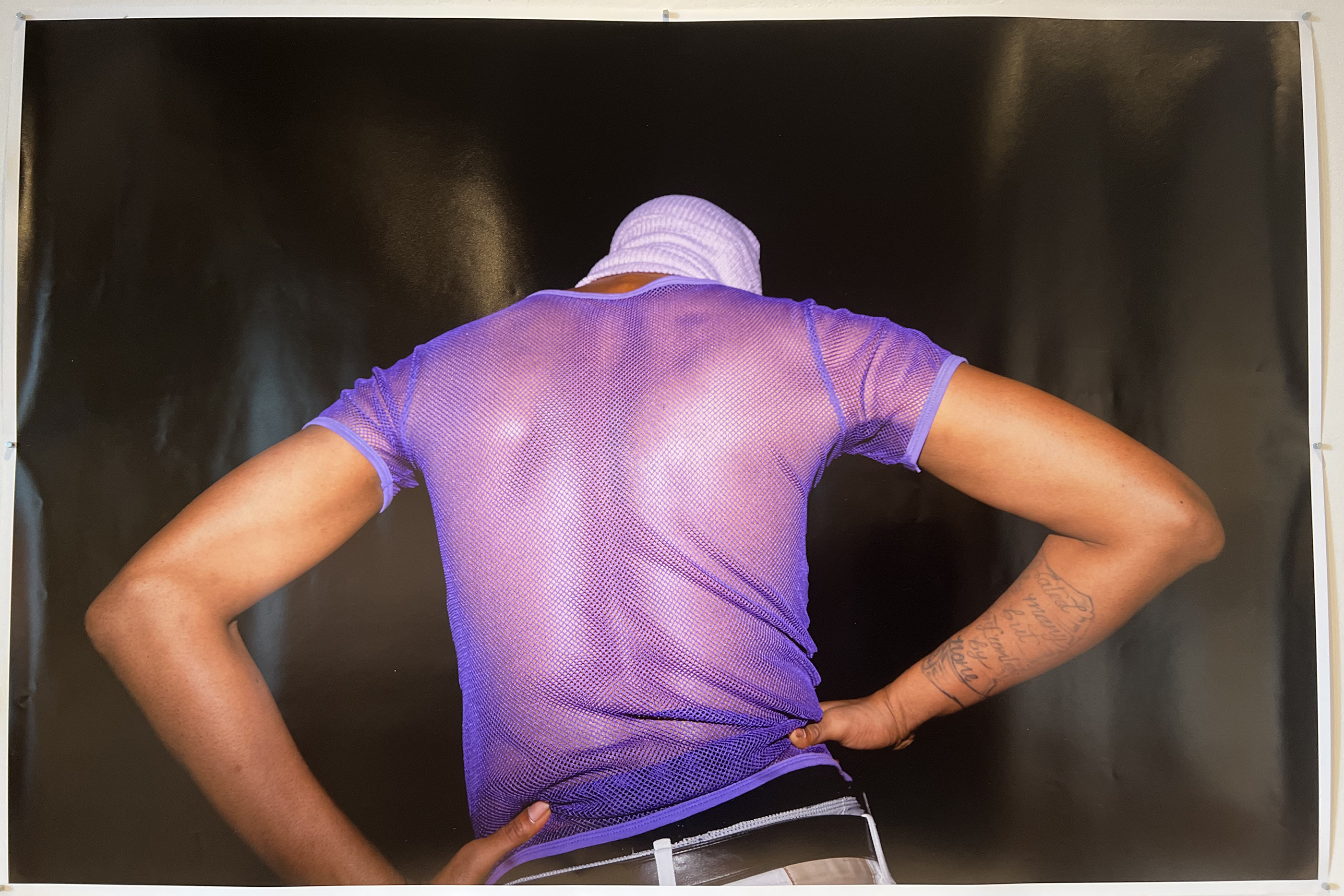 photograph of man in purple mesh top
