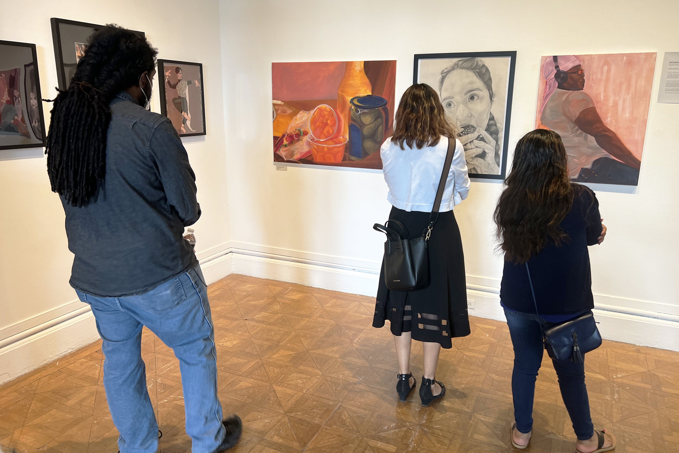 viewers take in POD student work at a show in Woods-Gerry Gallery