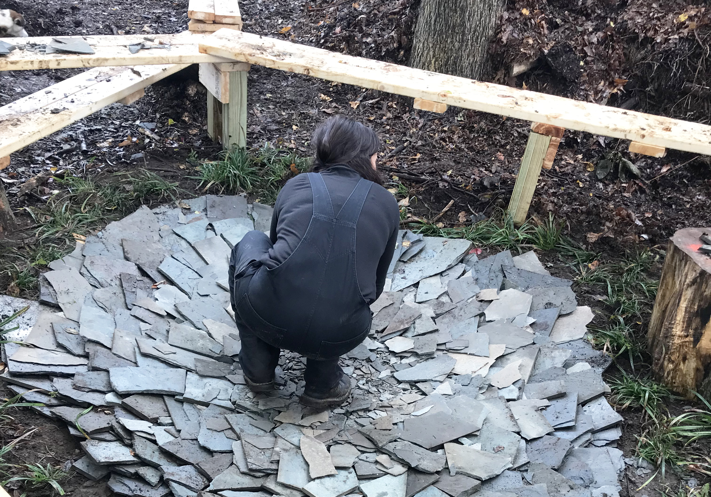 student works with broken slate found on site