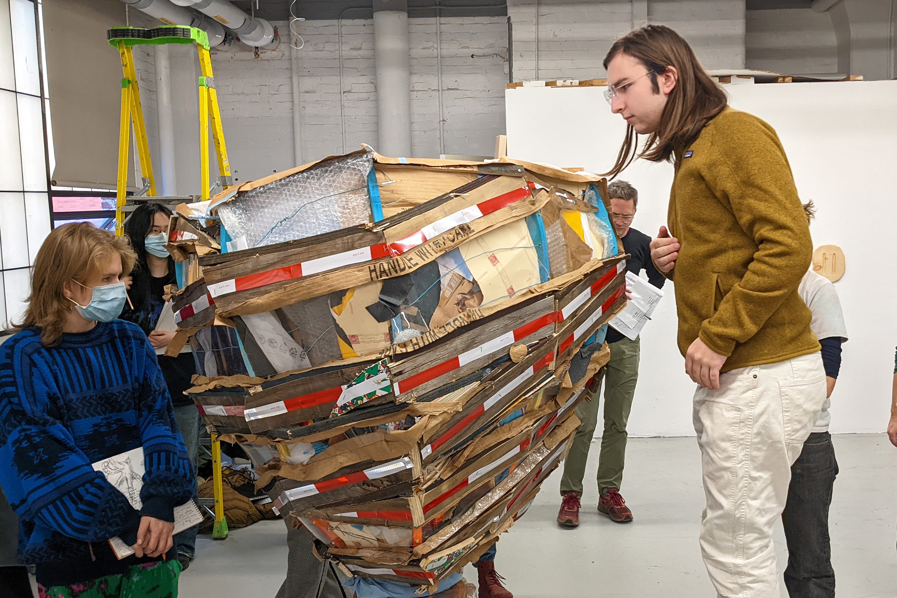 a student peers into a sculpture