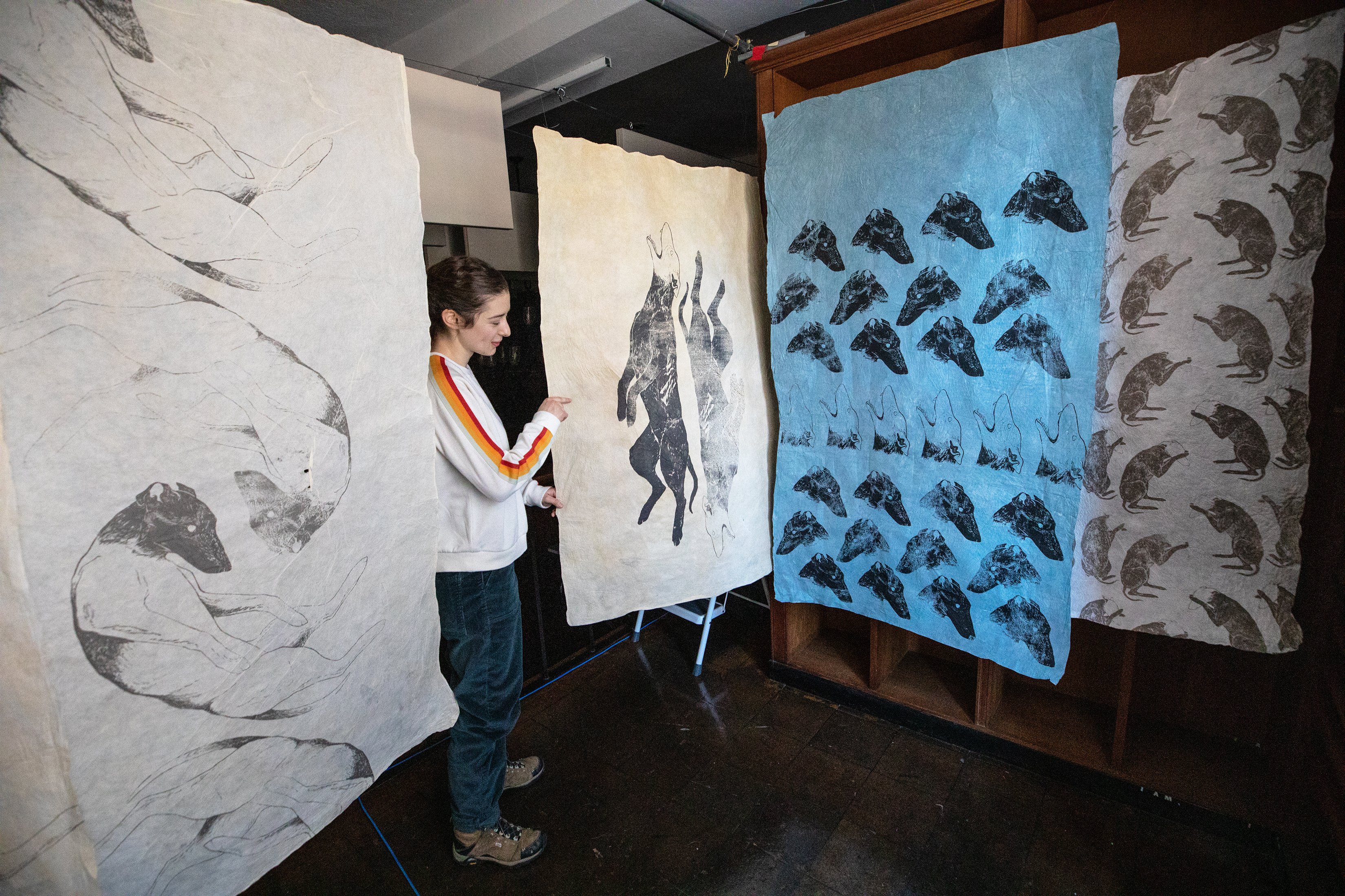Printmaking student hangs tapestries for critique