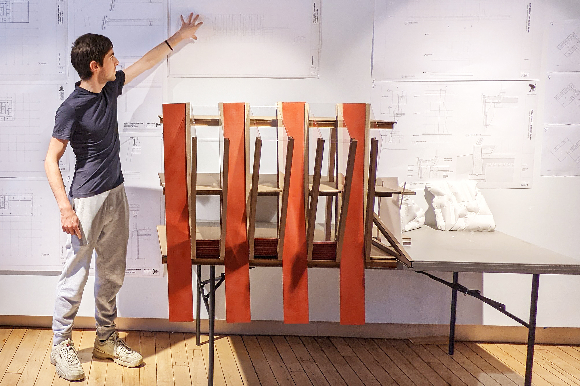 a grad student presents his team's designs at a crit