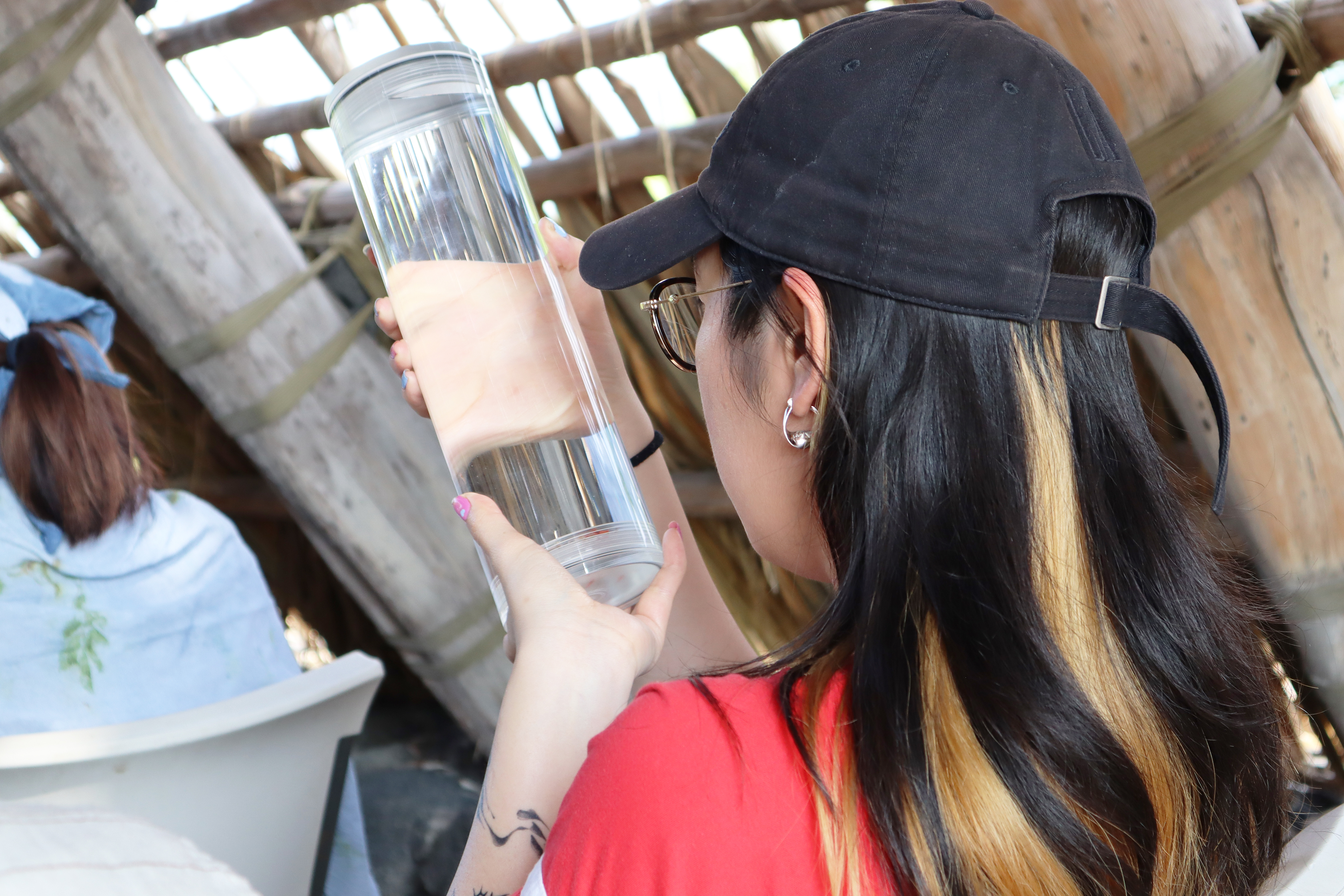 a student studies a specimen collected in a glass vessel