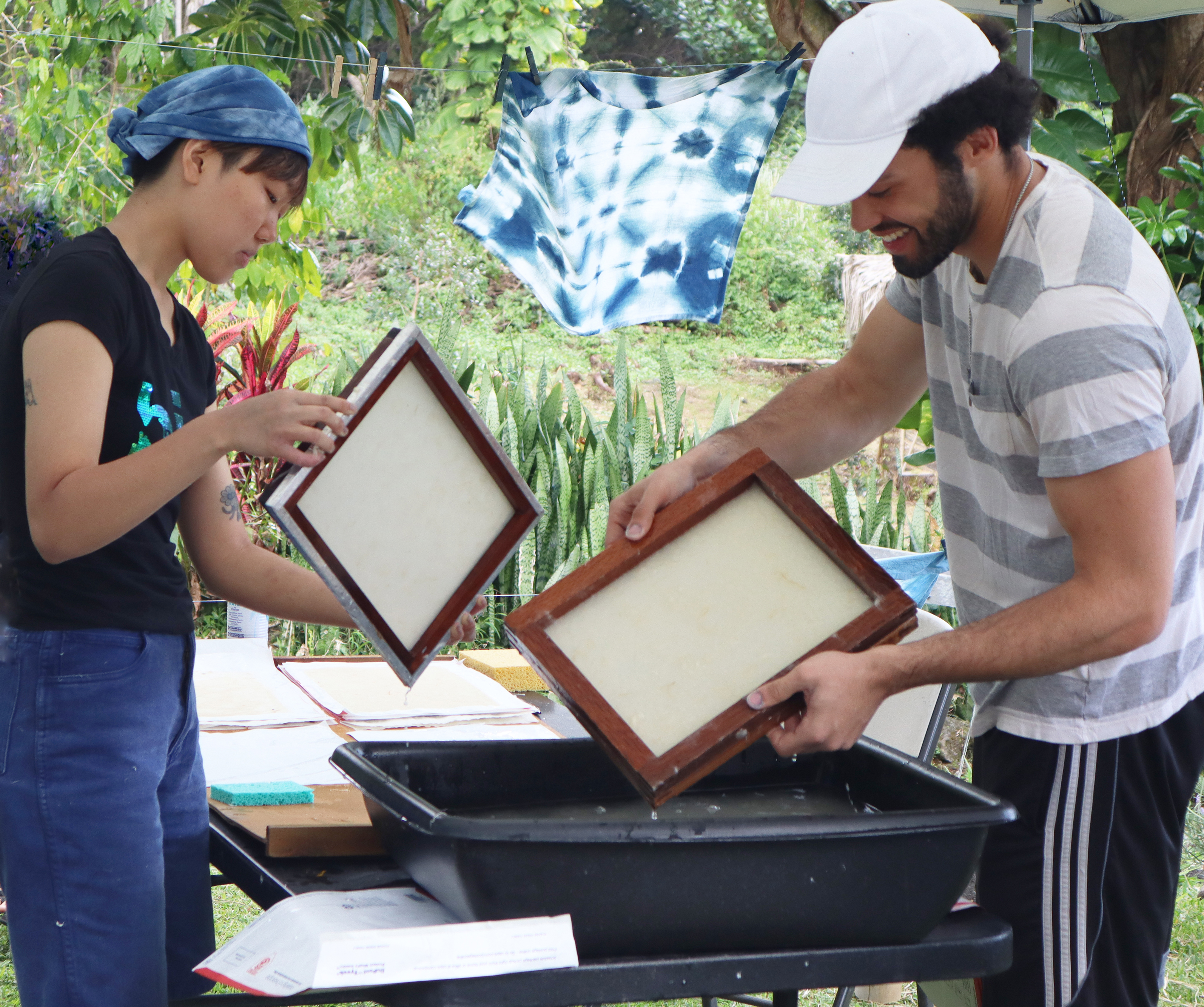 two students participating in outdoor paper-making workshop