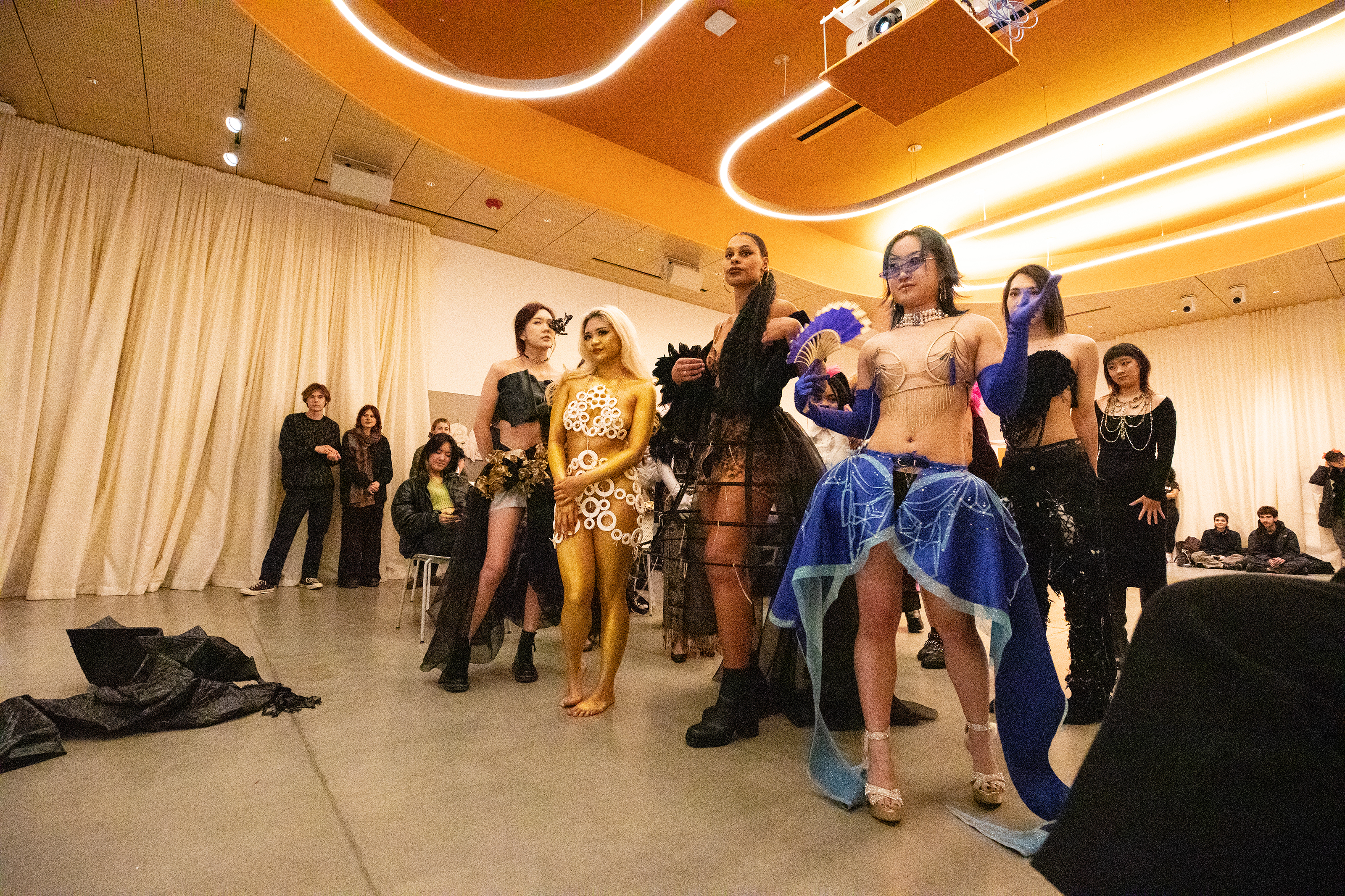 Students and models stand around waiting for awards to be announced at the end of the ball