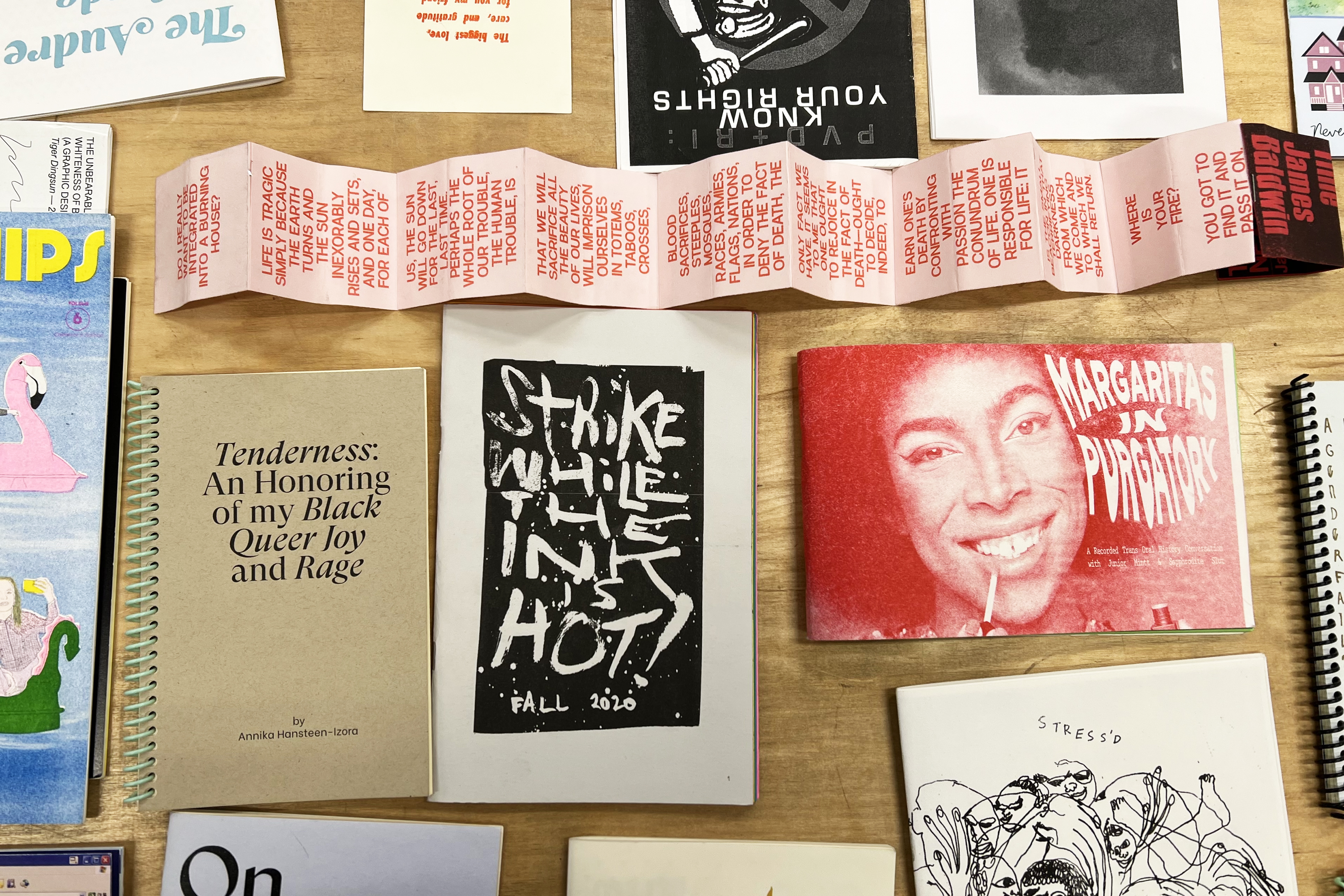 Colorful zines laid out on a table at Queer.Archive.Work
