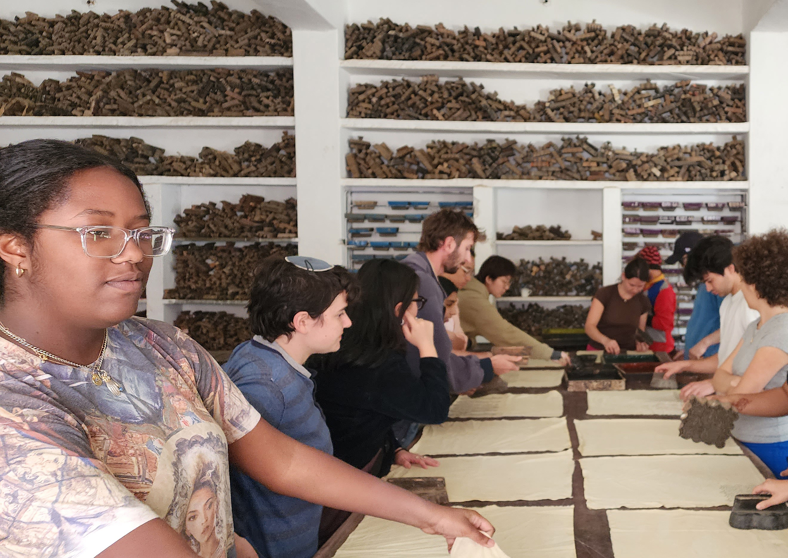 students gathered at a table during printing workshop