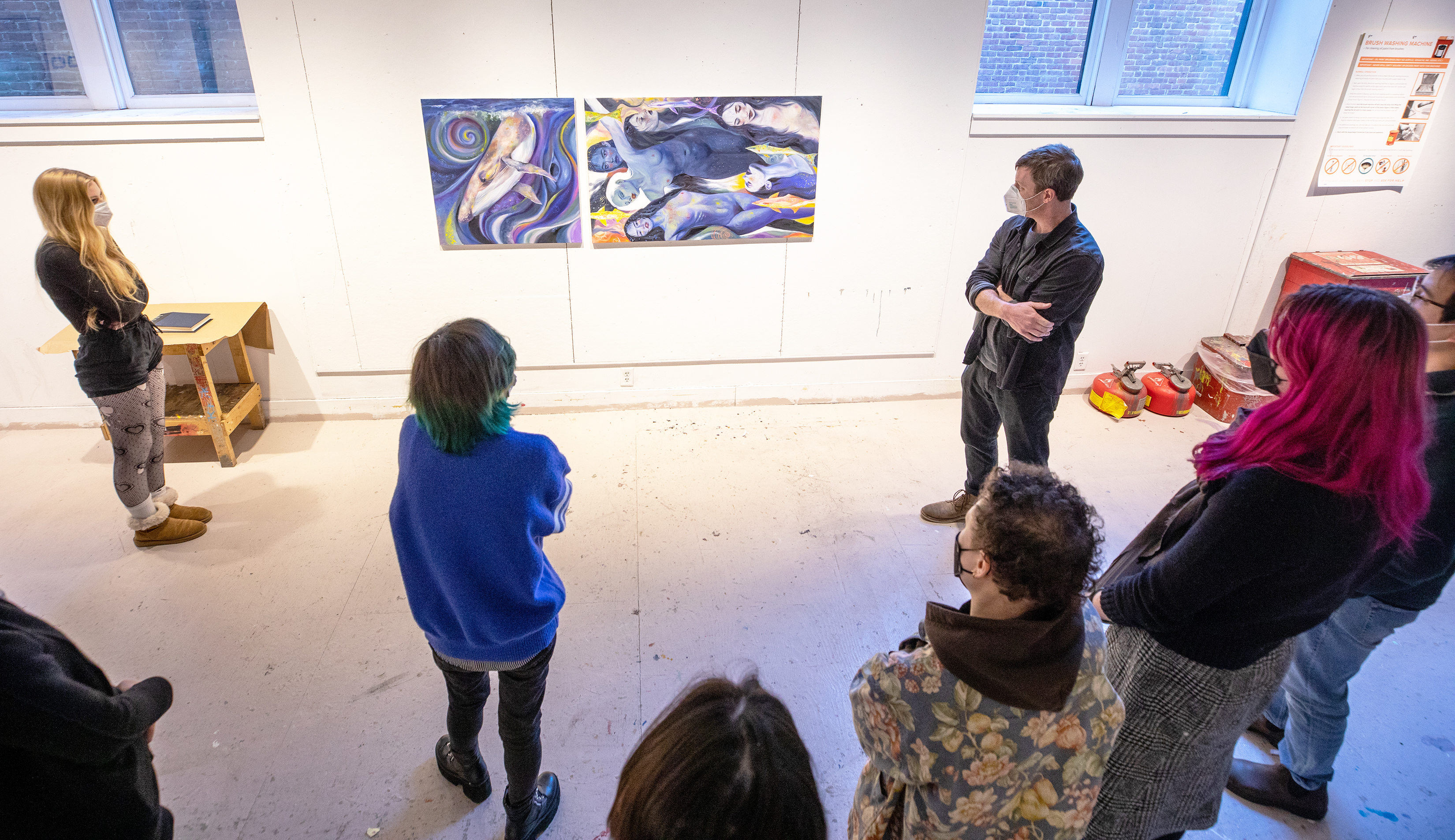 student presents paintings at final crit
