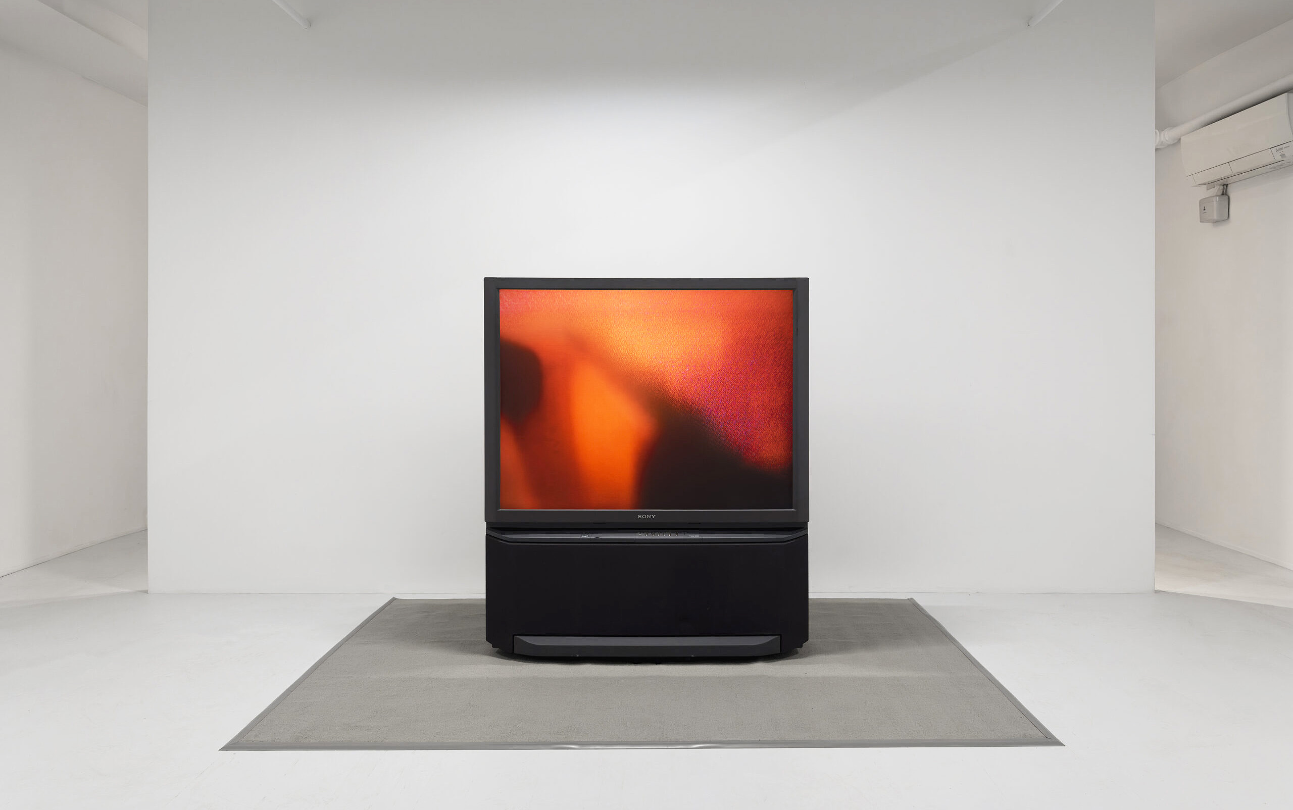 square video monitor showing Okokon piece in gallery