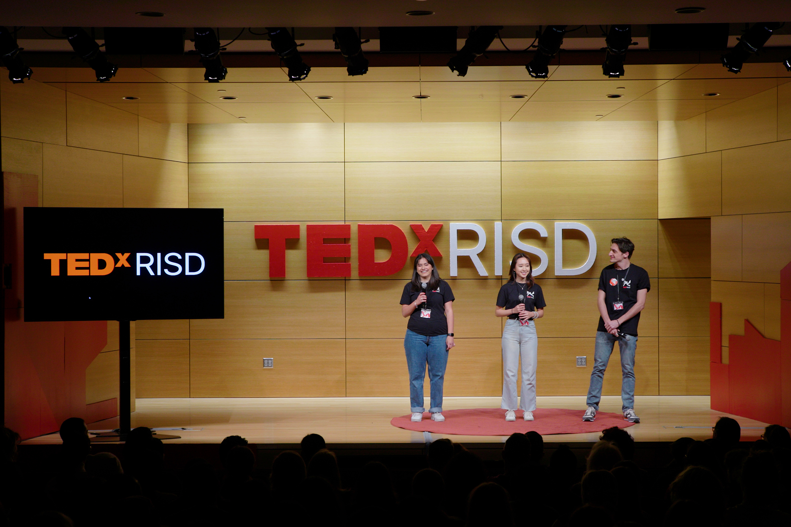 Student organizers stand on stage in the metcalf auditorium