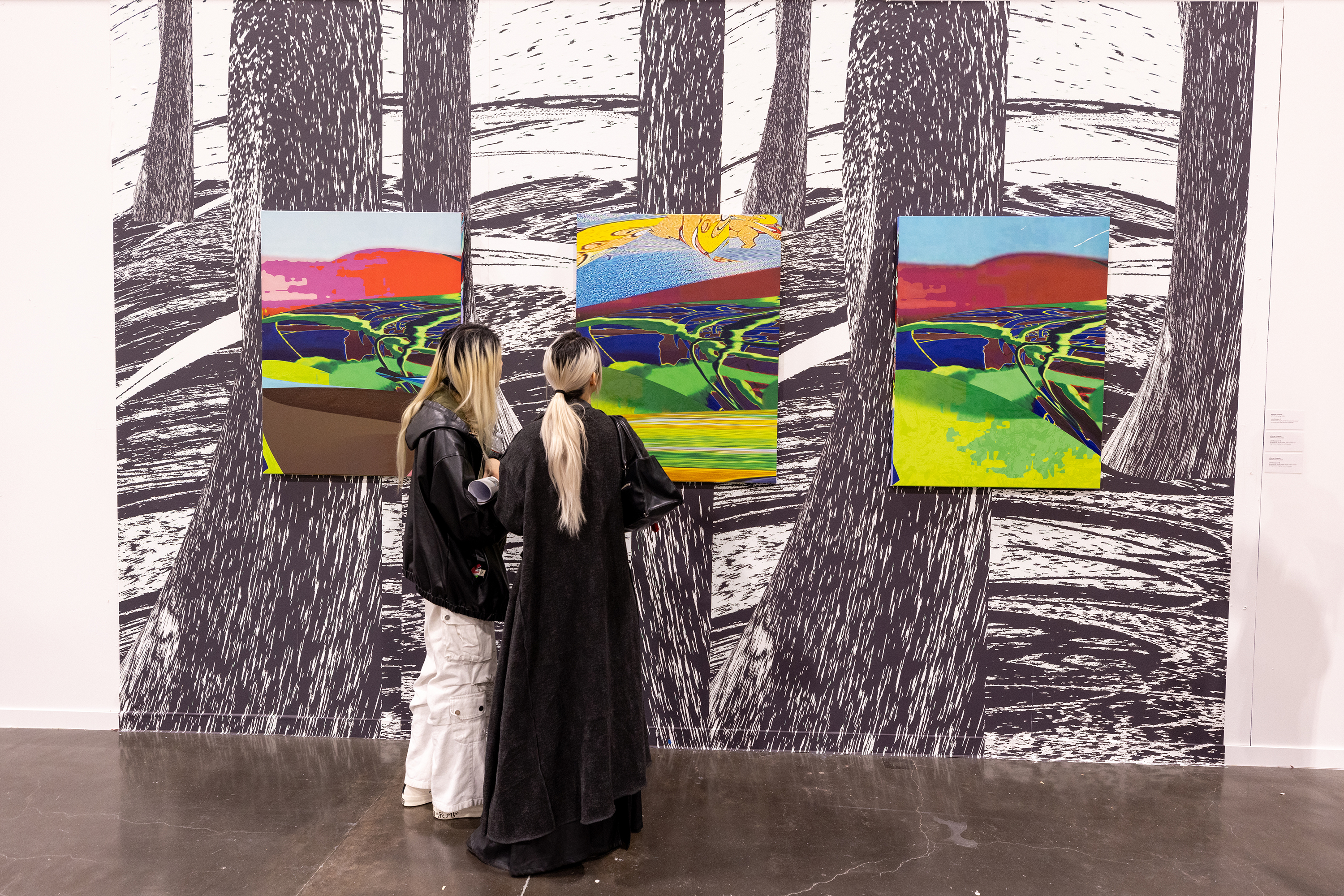 two women examine prints by Alfonso Vicencio