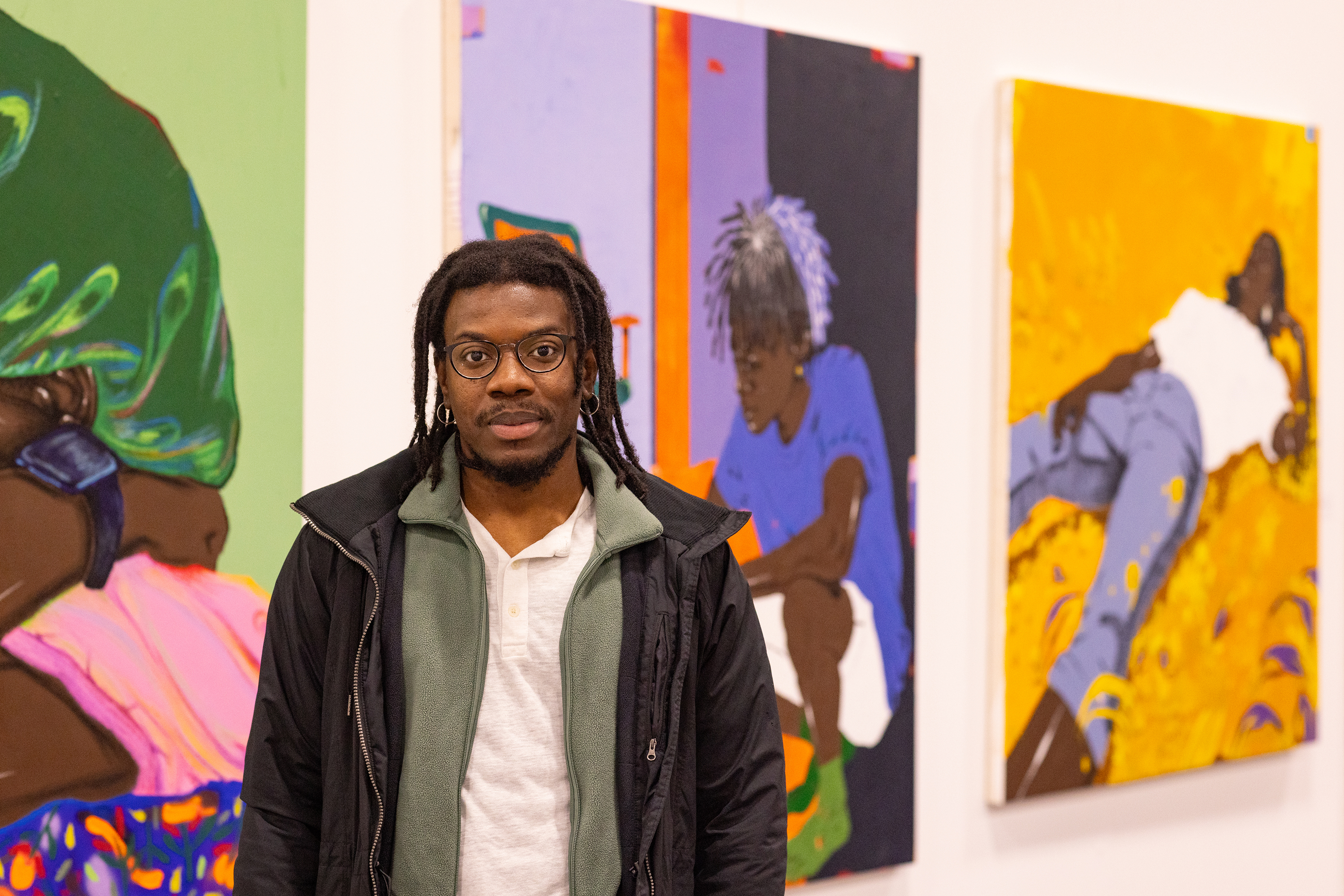 David Legrand poses in front of his colorful paintings