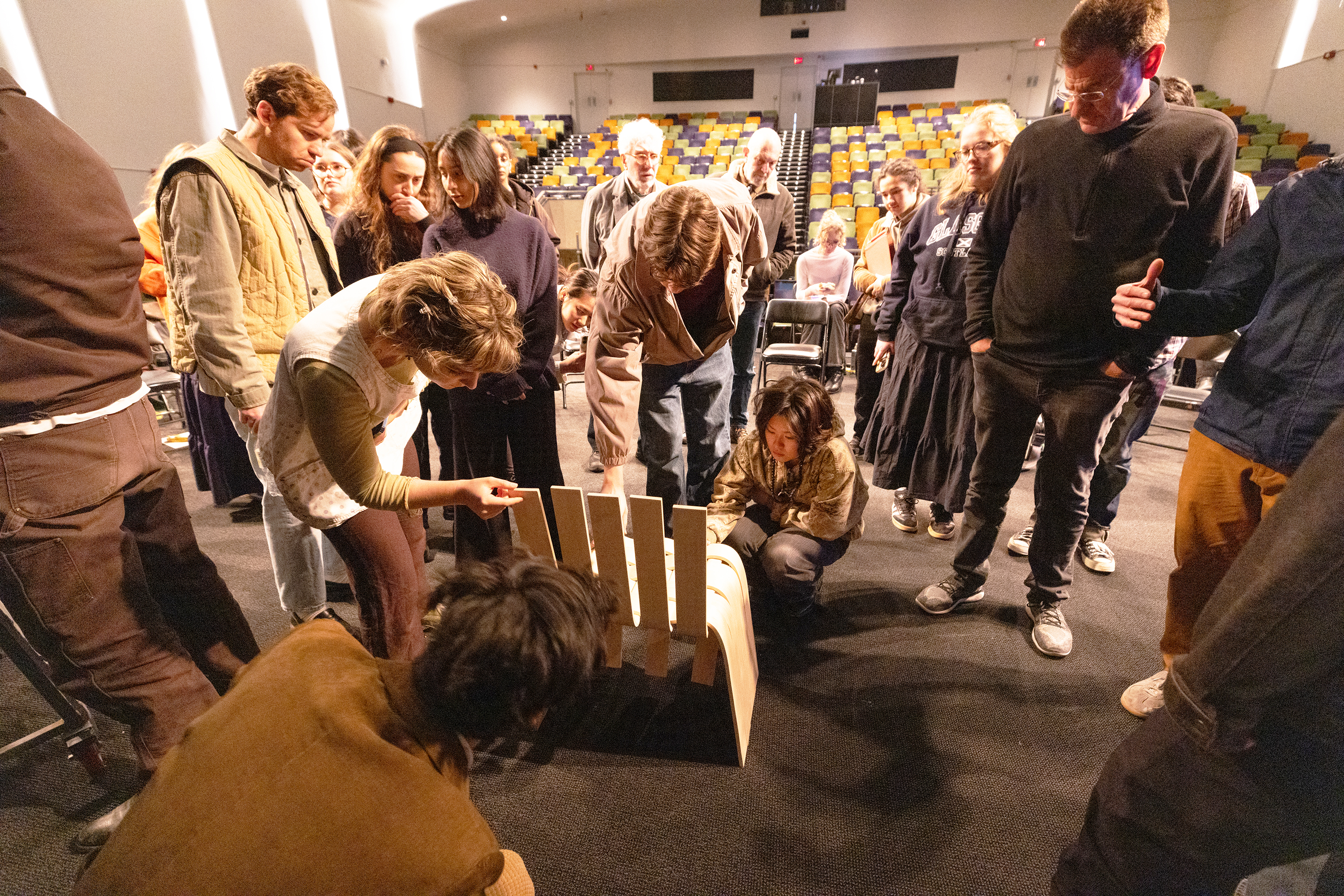 students gather around a woven chair by Furniture Design student Elizabeth Che