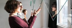 Instructor explaining a hanging glass sculpture to students