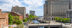 a length of the Providence riverwalk with view of the Point Street Bridge in the distance