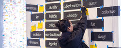 workshop leader at New Space(s) assembling a board of goals and adjectives that describe the future of the institution