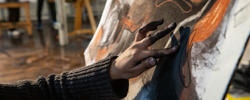 Close up of a first year EFS student putting the finishing touches on their charcoal drawing