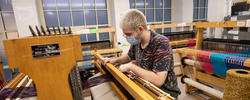 Student weaving in textiles studio.