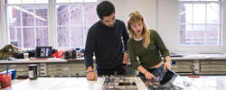 Two students looking at prints.