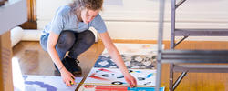 student is placing different prints onto the ground in a studio space