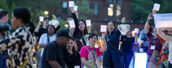 RISD alumni and students on the pedestrian bridge with lanterns 