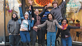 Children jumping for joy in front of an art center