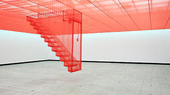 Alumni artwork installation displaying floating pink stairs in the center of a large empty room