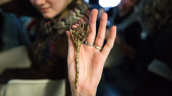 student holding a gnarled vines pendant
