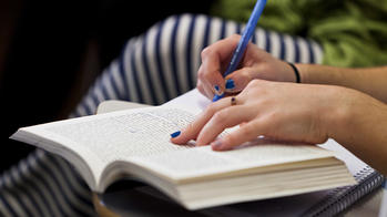 student writing in a book