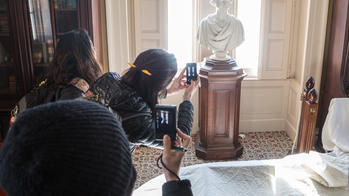 students photographing a sculpture