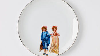 white ceramic dish with figures painted in color