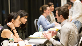 Two reviewers discuss a RISD student's portfolio at the Design Portfolio Review