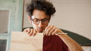 ID student measuring wood.