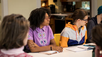 Two student at table during liberal arts class.